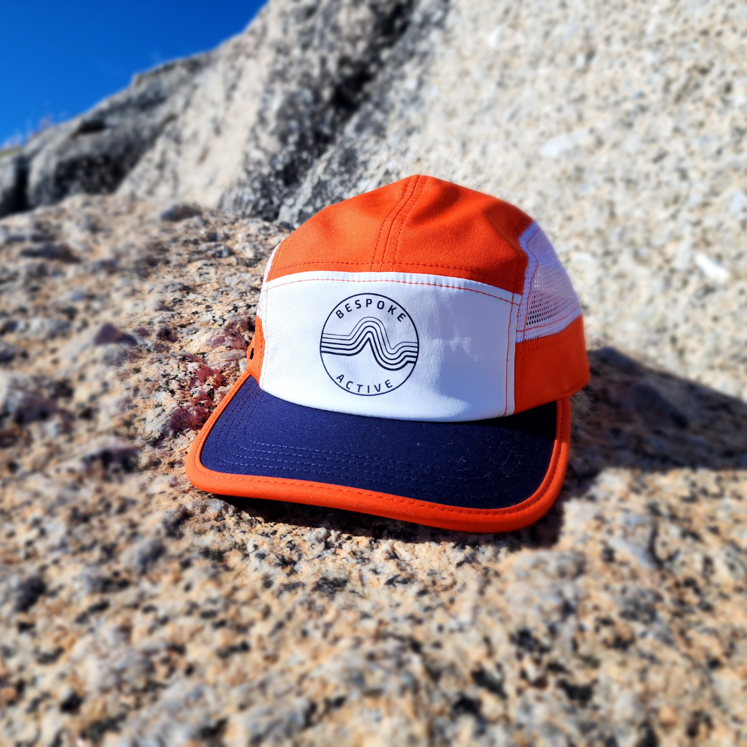 Orange and blue cap with a logo on a rocky surface